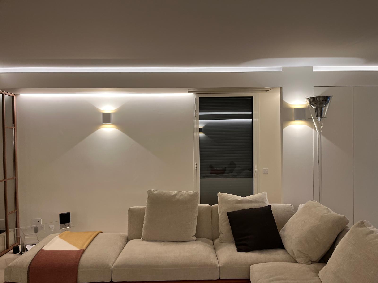Salon avec canapé, appliques murales et éclairage périphérique au plafond — chantier CAREN